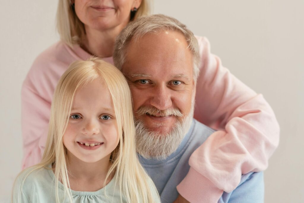 Three generations coming together with warmth and smiles in a studio setting.